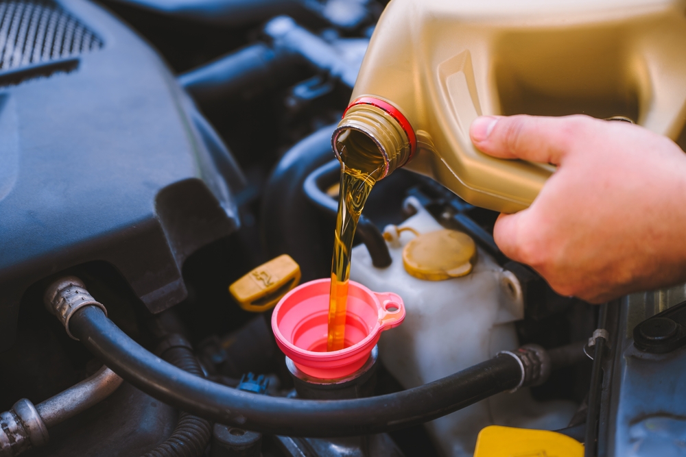 Pouring engine oil during vehicle maintenance